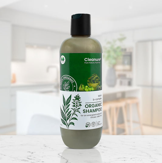 Bottle of Cleanure organic shampoo on a marble surface with a blurred indoor background