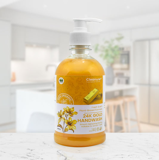 Bottle of 24K Gold Handwash on a marble surface with a blurred indoor background