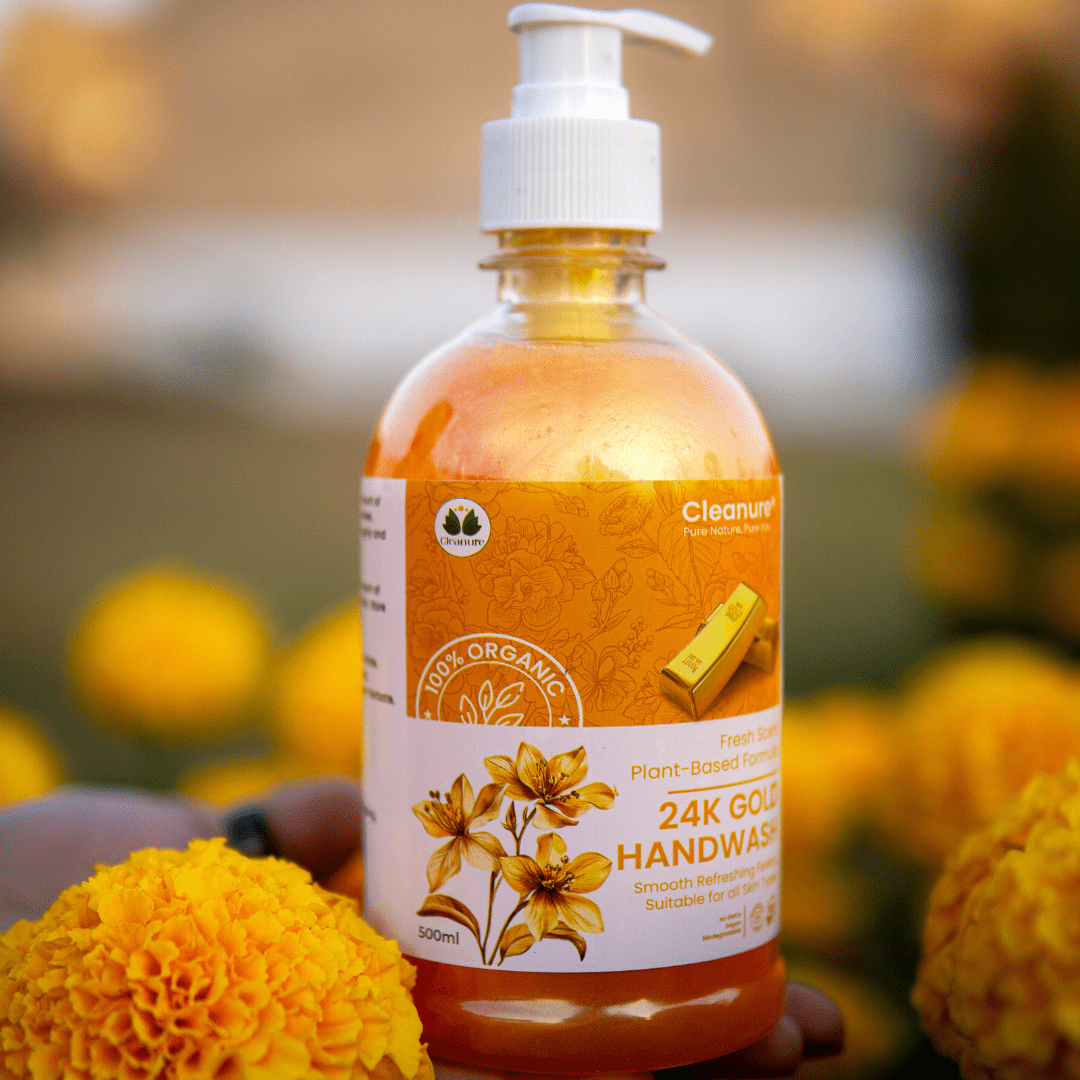 Bottle of 24K Gold Handwash with marigold flowers in the background