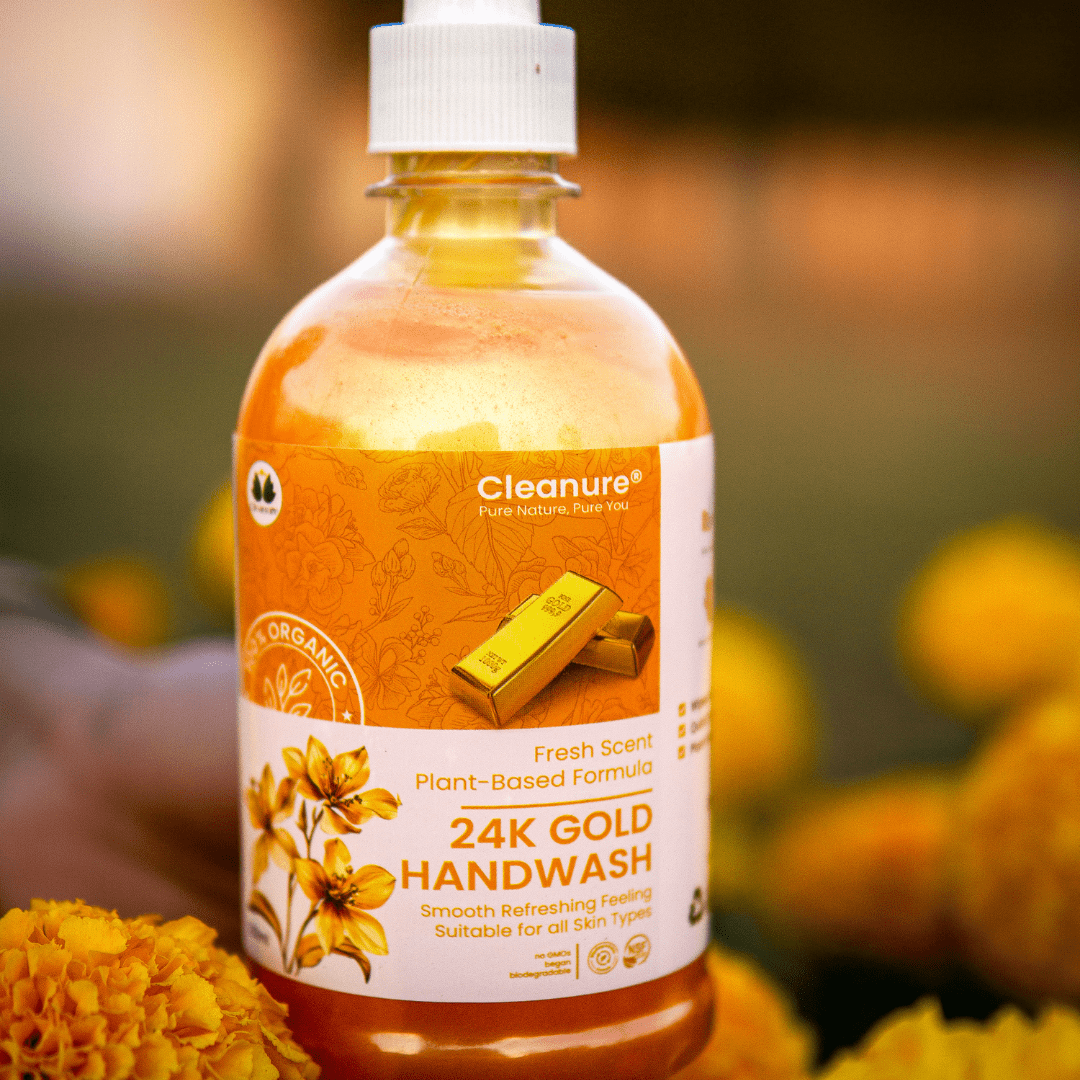 Bottle of Cleanure 24K Gold Handwash with marigold flowers in the background