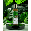 Herbal oil bottle with green leaves in the background